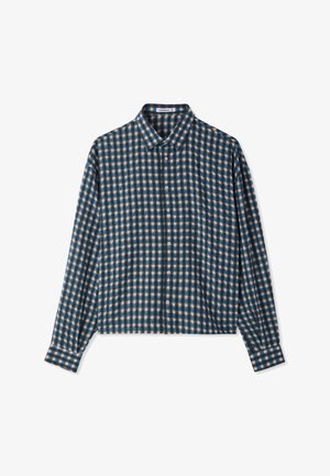 Camicia a maniche lunghe con pattern a quadri blu, neri e bianchi, colletto a punta e polsini abbottonati, poggiata piatta su sfondo bianco.