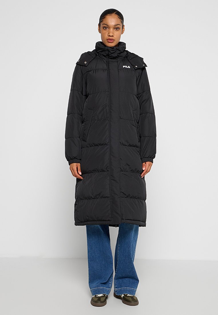 Zwarte gewatteerde lange jas met hoge kraag, ritssluiting en zijzakken. Heeft een logodetail op de bovenste linkerkant en een gequiltde textuur.