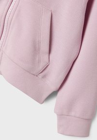 Helles rosa Zip-Up Hoodie aus geripptem Material, mit einer Fronttasche und gerippten Bündchen an den Ärmeln und dem unteren Saum.