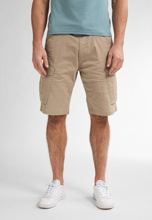 Beige cargoshorts met zijzakken, gemaakt van een duurzaam materiaal. Heeft een rechte pasvorm en een omgeslagen zoom. In combinatie met witte sneakers.