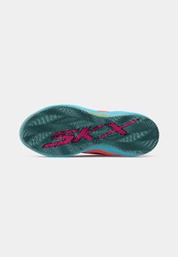 Semelle d'une sneaker multicolore avec un motif de bande de roulement bleu et noir et de grandes lettres roses "SKX" sur toute la semelle.