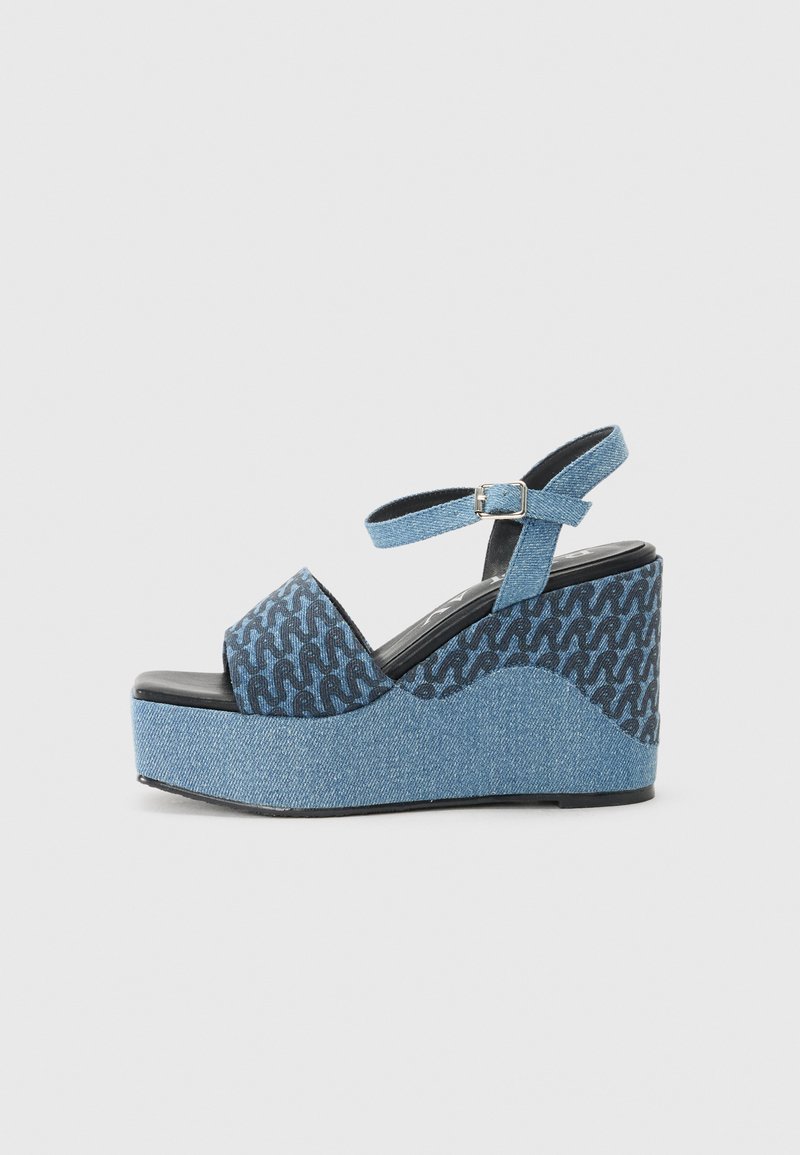 Denim platform sandals with a closed toe, ankle strap, and blue patterned accents; featuring a textured wedge and black outsole.