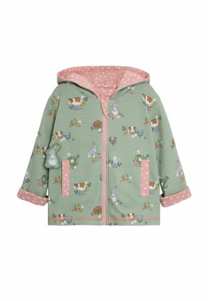 Giacca con cappuccio verde con motivi animali e floreali, dettagli rosa e fodera a pois. Dispone di tasche e chiusura frontale con zip.