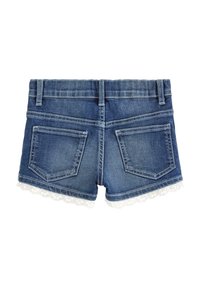 Jeanshorts med en tætsiddende talje, fem bæltestropper, to baglommer og en hvid broderet blondekant langs kanten. Mørkeblå farve.