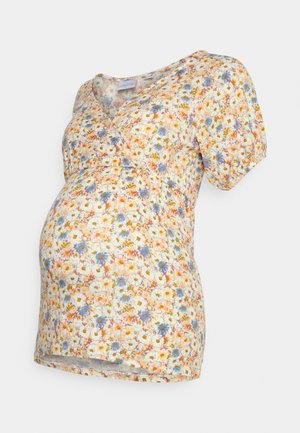 Blusa de maternidade floral com mangas curtas, apresentando um decote em V, cintura franzida e um tecido leve adornado com flores em tons pastel e detalhes verdes.