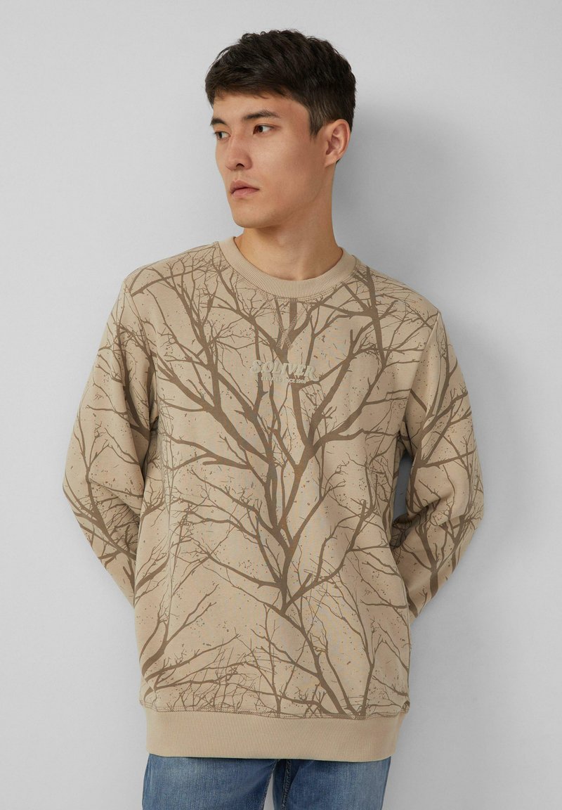 Felpa beige con stampa di rami d'albero marroni, scollo a girocollo a coste e polsini. Mostra il logo "SOLVER" sul davanti.