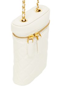 Borsa bianca in pelle trapuntata con hardware dorato, dotata di chiusura a zip e tracolla a catena. Texture liscia e design ovale compatto.