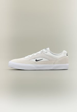 Valge madala lõikega toss musta Nike logoga, paelakinnitusega disain, seemisnahast ja võrkdetailidega ning valge kummist tald neutraalsel taustal.