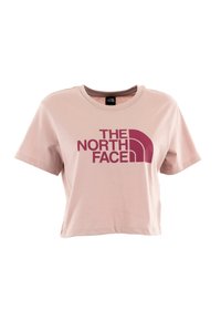T-shirt rosa in cotone cropped con un grande logo bordeaux di "THE NORTH FACE" sul davanti, con scollatura rotonda e maniche corte.