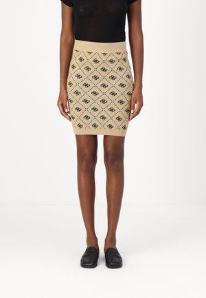 Knit mini skirt in beige with a diamond pattern and black accents. Features a ribbed waistband and smooth texture. Paired with black loafers.