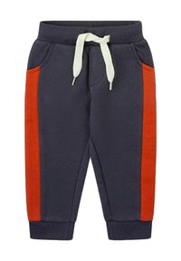 Pantalones deportivos azul marino con rayas laterales rojas, cintura elástica con cordón, bolsillos frontales y puños acanalados. Material de algodón suave.
