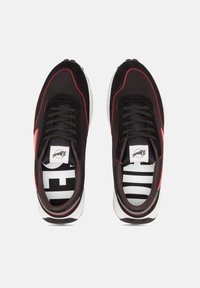 Chaussures de sport noires et rouges en suède et mesh, avec un bout arrondi, des lacets noirs et une semelle intermédiaire blanche avec une semelle intérieure à motif.