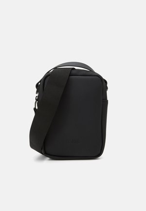 Borsa a tracolla nera realizzata in materiale impermeabile, con forma rettangolare, tracolla regolabile e design minimalista con dettaglio del logo.