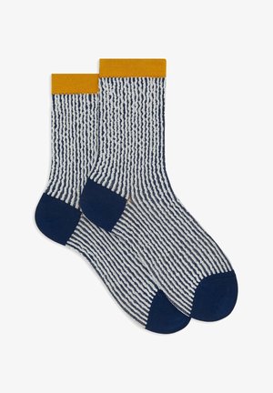 Gestreifte Socken in marineblau und weiß mit einem gelben gerippten Bündchen. Sie verfügen über ein strukturiertes Muster und feste marineblaue Fersen- und Zehenbereiche.
