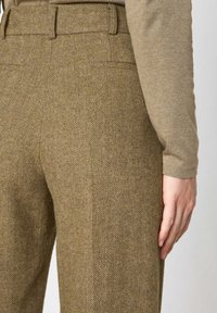 Pantaloni realizzati in tessuto a spina di pesce verde oliva, caratterizzati da una vita alta e un design snello con cuciture dettagliate.