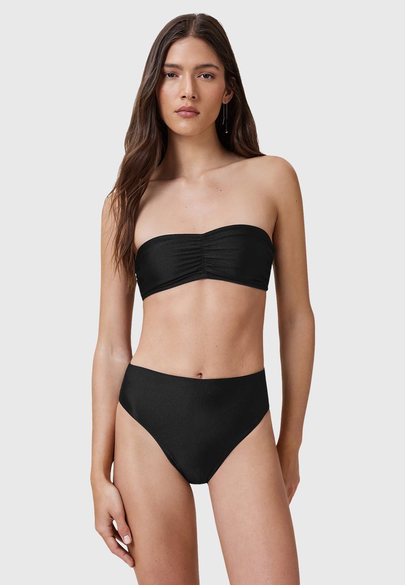 Svart bandeau bikiniöverdel med samlingsdetalj; högmidjade bikinitrosor i matchande svart; slät textur och minimalistisk design.