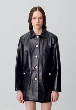 Veste en cuir noir avec un col, des boutons dorés et deux poches avant. Texture lisse et coupe ajustée.