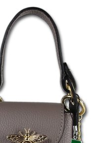 Braune Lederhandtasche mit goldenem Bienenemblem, strukturierten Oberfläche, kurzem Tragegurt und goldenen Hardwaredetails. Kleines grünes und silbernes Schlüsselanhänger befestigt.