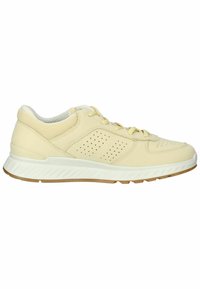 Light yellow athletic shoe with perforated design, padded collar, rubber outsole, and textured detailing on sides for grip.