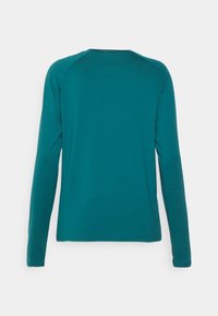 Camisa de manga longa em tom azul-petróleo, feita de um tecido liso, com decote redondo e mangas raglan. Sem padrões ou acentos visíveis.