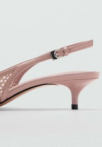 Różowe sandały na obcasie z teksturowanym, wyciętym wzorem. Posiadają smukły pasek oraz krótki obcas w stylu stiletto, co podkreśla ogólną elegancję.