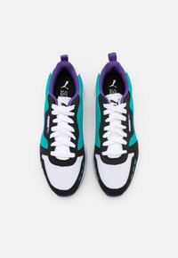 Baskets avec tige en mesh de couleur sarcelle, noir et blanc, dotées d'un insert talon violet, de lacets blancs et d'une semelle intérieure à logo. Design sportif moderne.