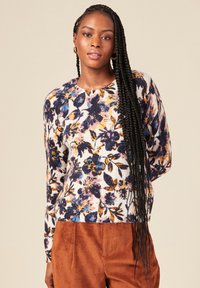 Maglione con motivo floreale in crema, caratterizzato da tonalità blu, giallo e rosa. Collo rotondo classico e maniche lunghe. Morbido tessuto a maglia.