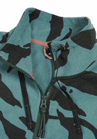 Fleece half-zip jas in teal met zwart camo-patroon. Heeft een hoge kraag, een trekkoord en contrasterende bruine ritsaccenten.