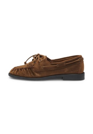 Zapato tipo mocasín de ante marrón con suela negra, cordones frontales y detalles decorativos de costuras, mostrado de perfil.