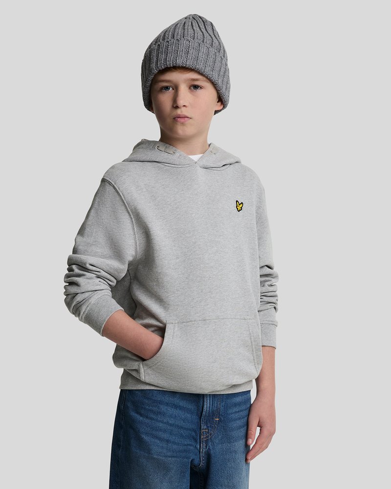 Felpa grigia con cappuccio e tasca frontale, dotata di un piccolo logo ricamato. Abbinata a jeans in denim blu. Il modello indossa un berretto di lana grigio.