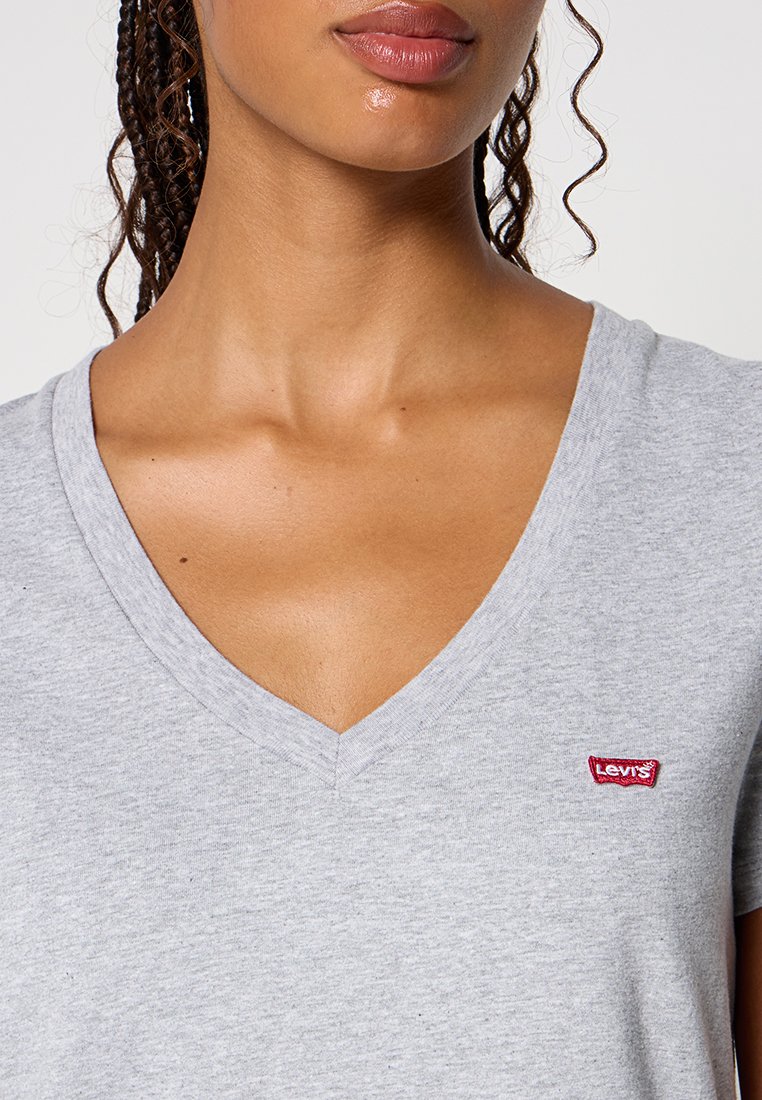 Graues V-Ausschnitt-T-Shirt aus weichem Baumwollstoff. Verfügt über ein kleines rotes Levi's-Logopatch auf der linken Brustseite.
