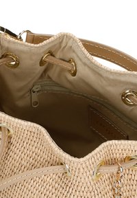 Béžová tkaná slaměná kabelka ve tvaru kbelíku s hnědými syntetickými koženými akcenty, zlatými kovovými prvky a zipovou vnitřní kapsou.