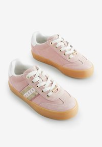 Tenisi roz din suede cu sireturi albe și talpă din cauciuc de tip gumă. Prezintă o dungi pe lateral cu accente aurii și detalii texturate, având inscripția "BAKER".