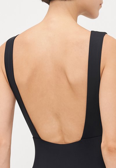 Black swimsuit with a deep back cut, wide straps, and a smooth texture, showcasing a minimalist design and clean lines.
