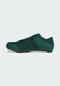 Green athletic shoe with a sleek design, featuring a mesh upper, curved toe, rubber outsole, and minimalist strap detail across the midfoot.