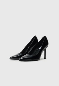 Pair of black patent leather pointed-toe high heels with stiletto heels against a plain white background.