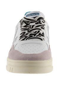 Vit sneaker med grå mockadetaljer, svart och vit mönstrade snören, perforerad tå och en ljus sula. Victoria-logotyp synlig.