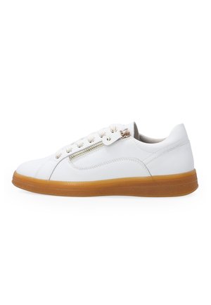White low-top sneaker with brown rubber sole, side zipper, and white laces on a plain white background.