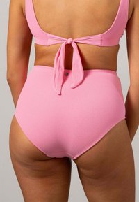 Rosa högmidjad bikiniunderdel i mjukt strukturerat tyg med snörning bak. Har en liten metalldetalj vid midjan.