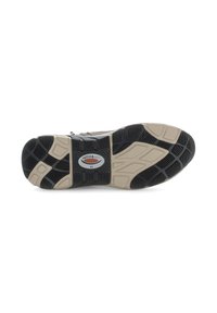 Semelle de sneaker avec un motif de semelle en caoutchouc noir et des accents beiges. Le design inclut un logo et plusieurs textures qui améliorent l'adhérence.
