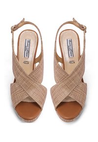 Sandali slingback beige con cinturini incrociati, upper testurizzato e tacco rialzato, dotati di una suola interna marrone liscia. Chiusura con fibbia alla caviglia.