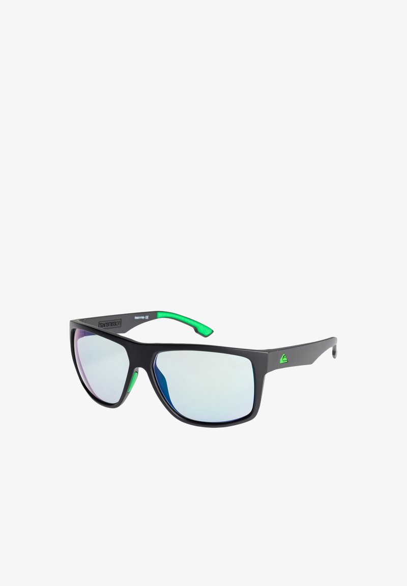 Gafas de sol negras con acentos verdes, lentes espejados que muestran un efecto de degradado, diseño angular y montura de plástico.