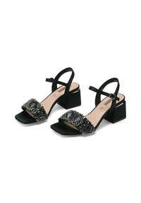 Sandali neri in suede con tacco a blocco e punta aperta, con un'applicazione di perline sul cinturino e un sottile cinturino alla caviglia per supporto.