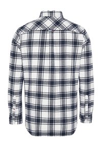 Camicia di flanella a maniche lunghe con un motivo a scacchi blu navy e bianco, polsini con bottoni e colletto classico. Tessuto morbido e testurizzato.