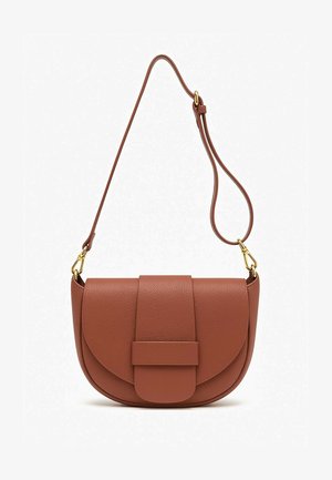 Beżowy oversizeowy sweter na drutach, maxi spódnica w cętki lamparta, brązowa torba na ramię i jasne espadryle. Gładkie tekstury i wyraziste wzory.