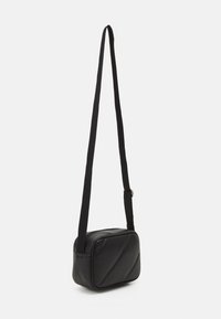 Borsa a tracolla nera in pelle con tracolla regolabile, forma rettangolare e dettagli con cuciture diagonali. Texture liscia con hardware minimale.