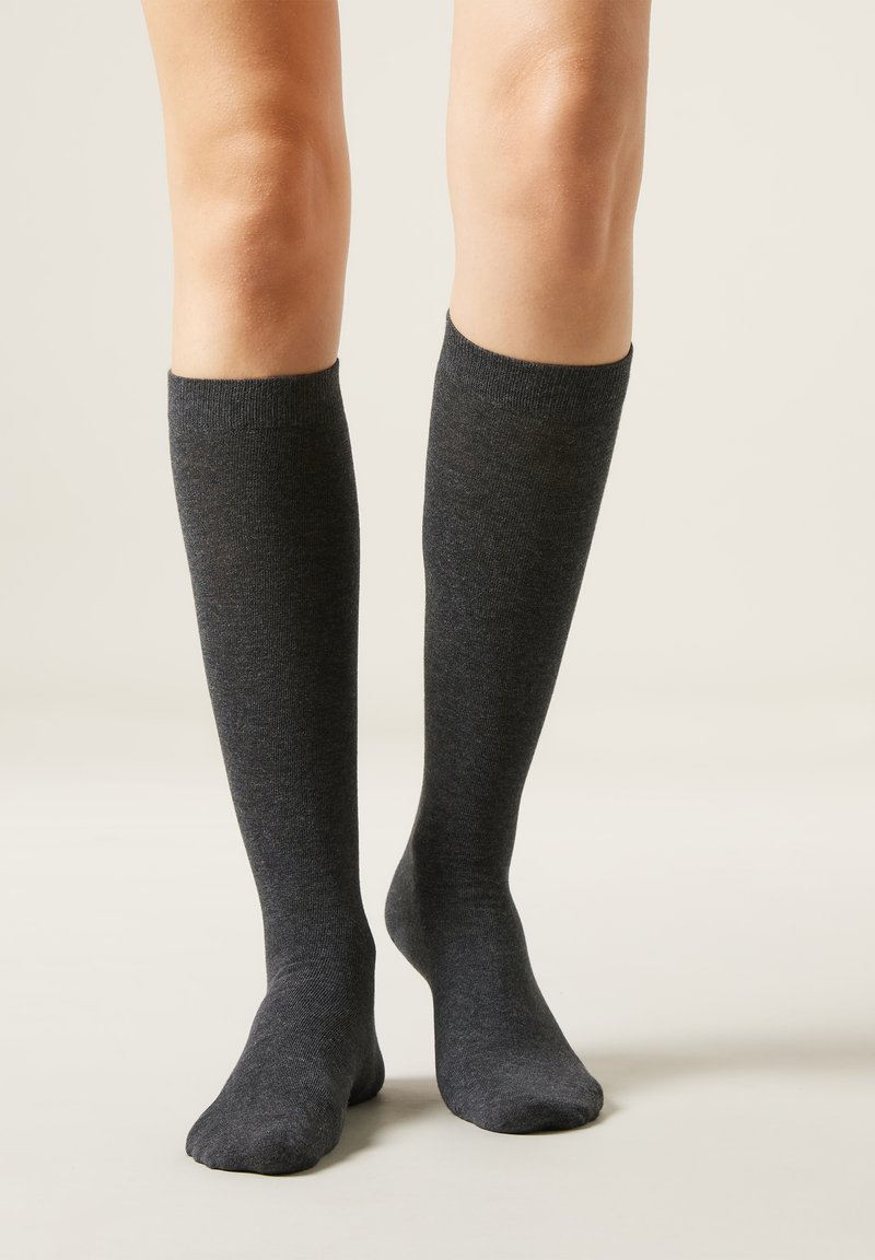 Knielange, charcoalgraue Socken aus weichem, gestricktem Material. Glatte Oberfläche mit einem gerippten Bündchen oben. Keine sichtbaren Muster oder Verzierungen.