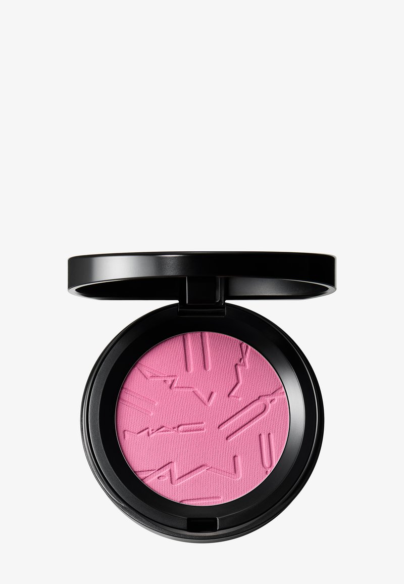 Boîtier compact rond noir avec fard à joues poudre pressée rose vif, comportant le nom de la marque et un design en relief, couvercle ouvert sur fond blanc.