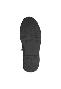Suela negra de un zapato con un agarre texturizado, patrones en forma de estrella y un borde suave. Incluye un lazo lateral para facilitar el tirón.