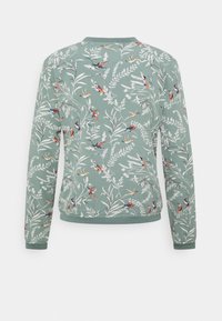 Ljusgrön tröja med blommönster och fåglar, tillverkad i mjukt tyg. Har långa ärmar och rund hals med ribbade muddar.